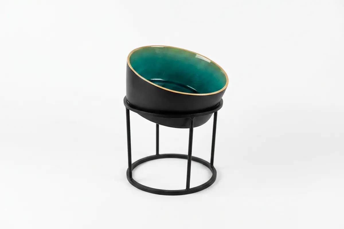 A teal and gold serving bowl presented on a black ring stand