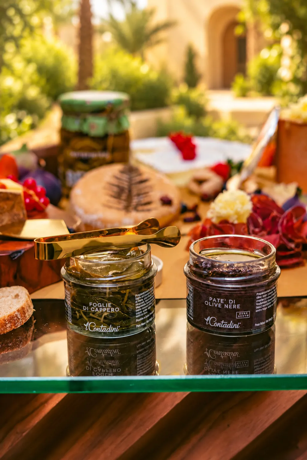 Jars of black olive paste and sundried tomato beside bread